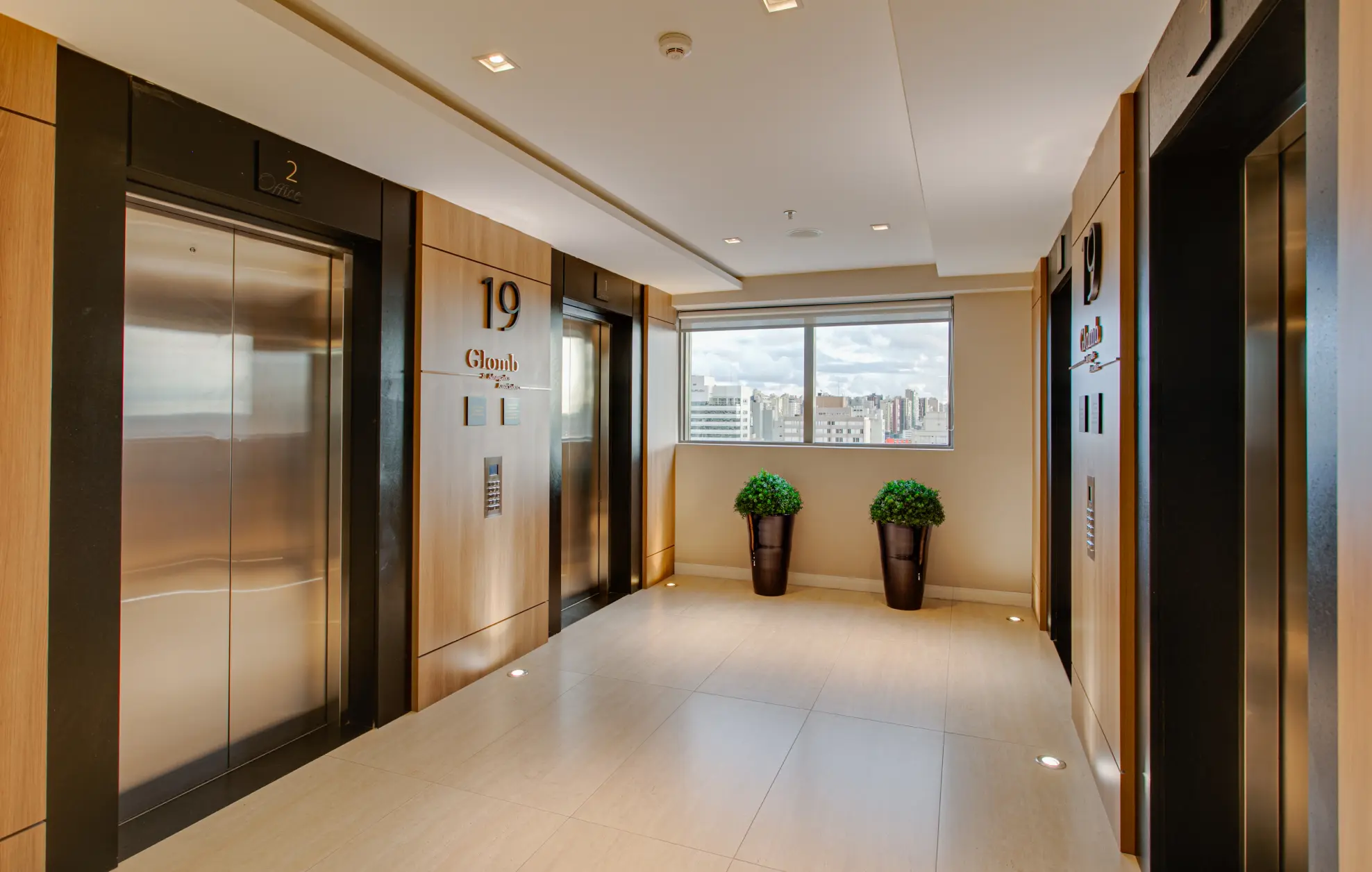 Corredor com os elevadores no 19 andar no edifício Universe em Curitiba/PR. A área do escritório contempla o andar inteiro.